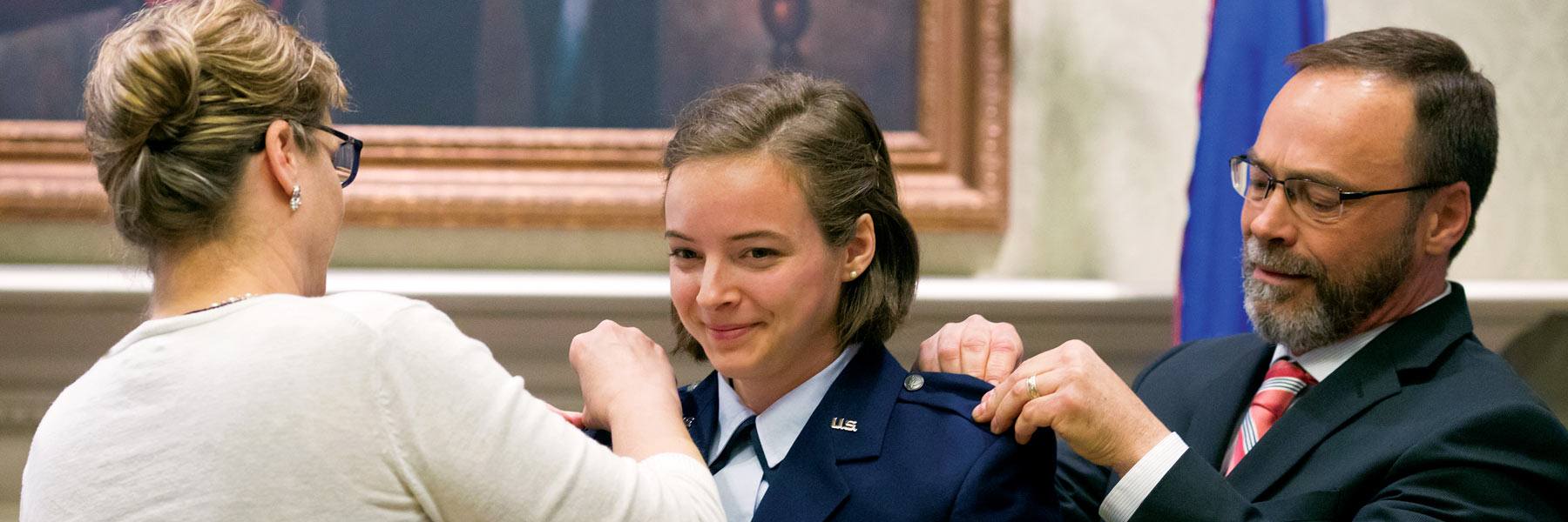 A female cadet receives pins at the commissioning ceremony.