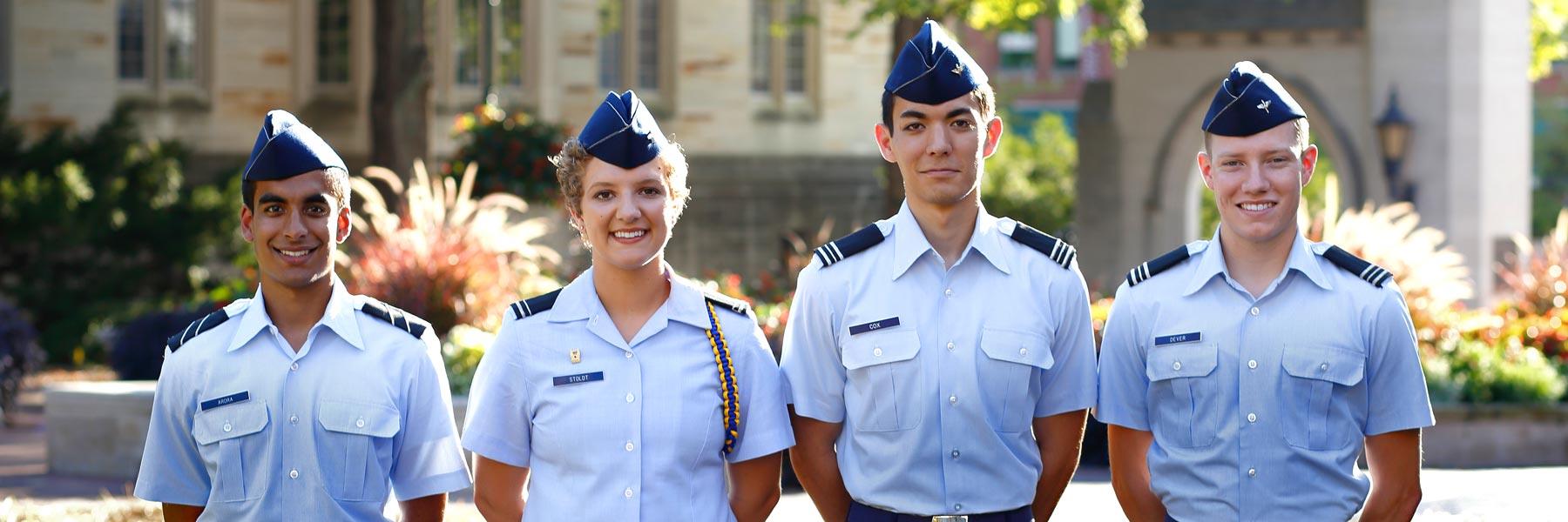 Four Air Force ROTC cadets stand in uniform in front of the Sample Gates at IU Bloomington.