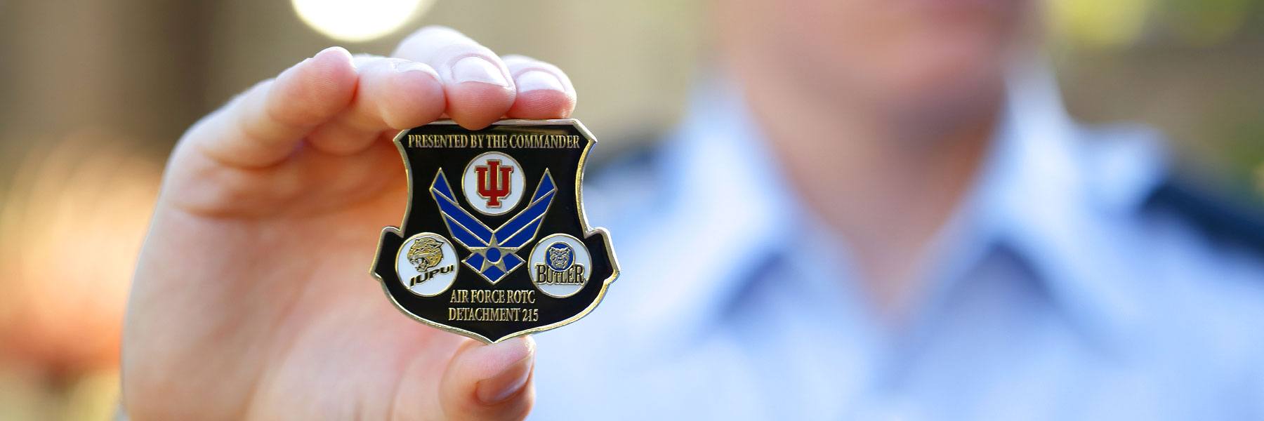 Cadet holding the Air Force ROTC Detachment 215 coin